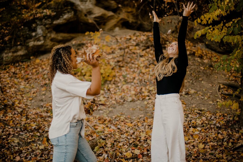 An Indiana Photographer captures two women throwing leaves in the air in west lafayette, Indiana at their LGBTQ session. 