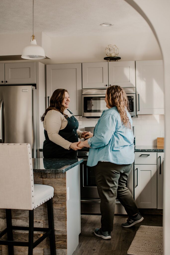 indianapolis indiana engagement photographer captures an lgbtq couple dancing in their kitchen at their engagement session in indianapolis, indiana 