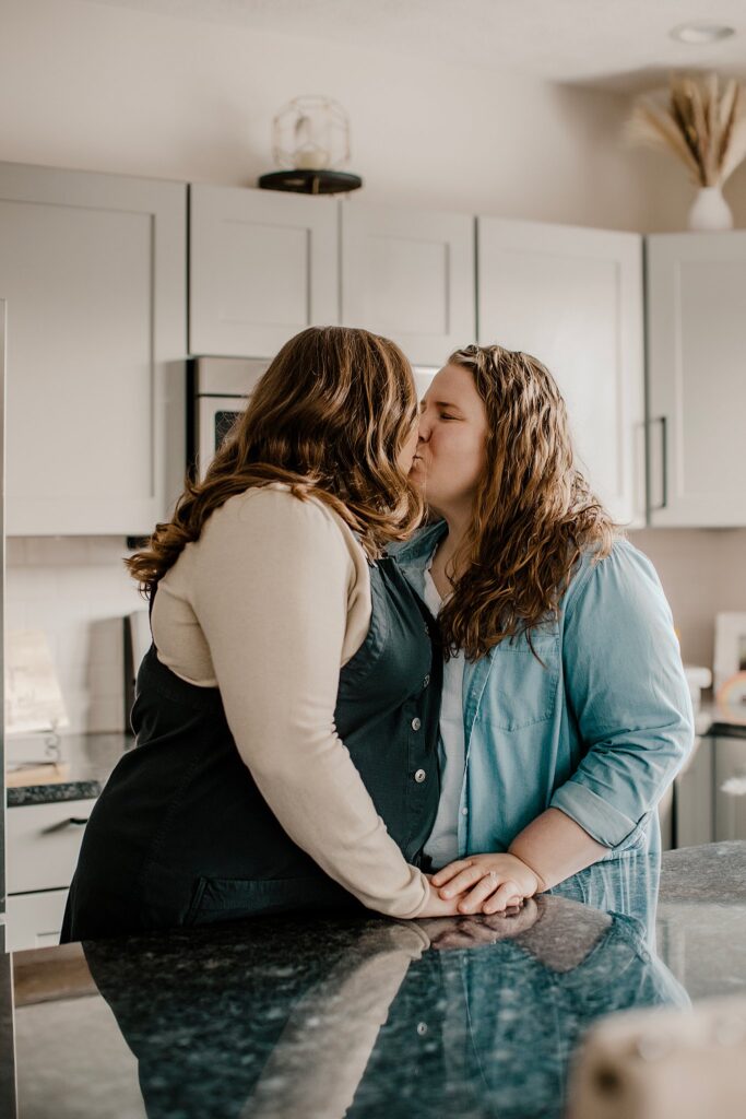 indianapolis indiana engagement photographer captures an lgbtq couple kissing in a kitchen at their engagement session in indianapolis, indiana 