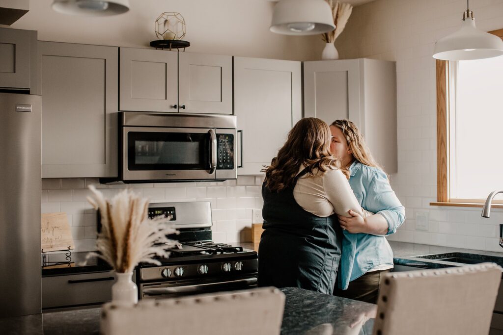 indianapolis indiana engagement photographer captures an lgbtq couple kissing in a kitchen at their engagement session in indianapolis, indiana 