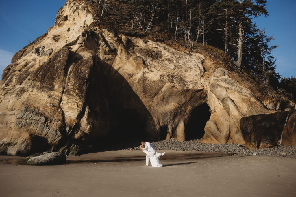 the ultimate oregon elopement guide couple kissing in front of hug point oregon