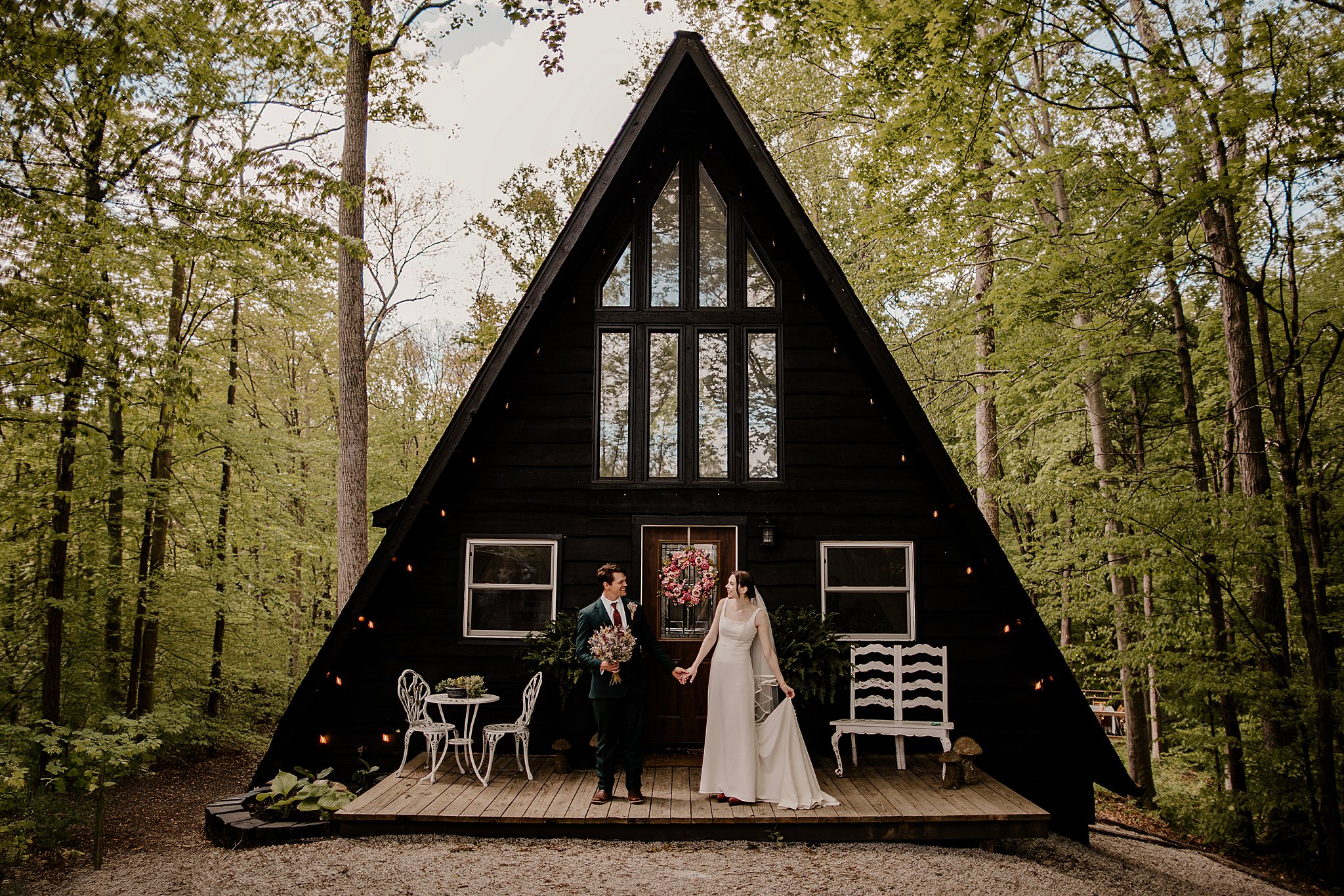 a man and wife get married at a cabin while holding hands in front of their A-frame near Turkey Run State Park